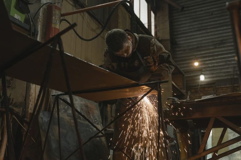 Fabricator welding a steel assembly in the shop.