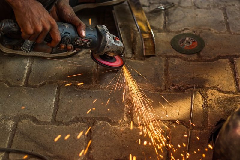 Angle grinder dressing a weld, sparks flying.